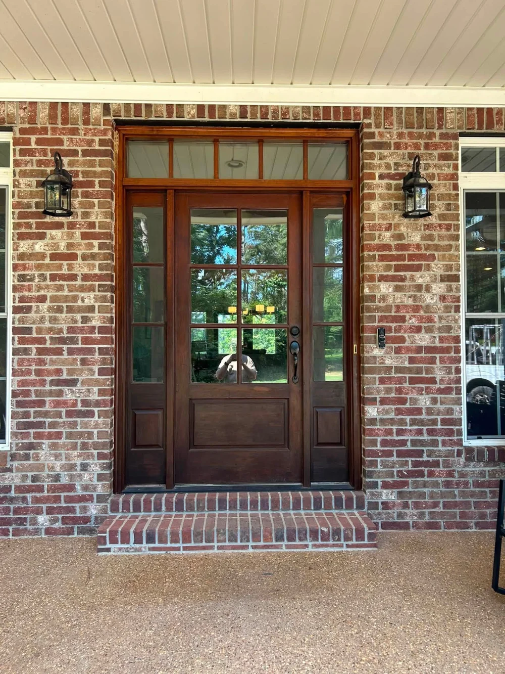 Exterior light fixtures beside a brick home entry