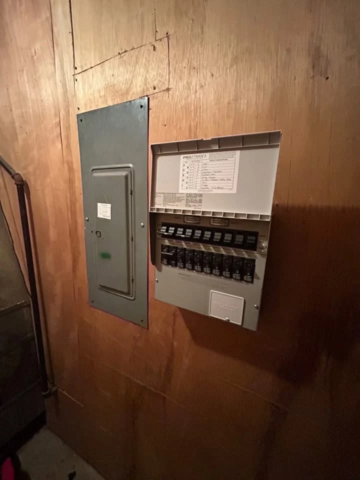 An opened residential electrical panel showing breakers and circuit wiring